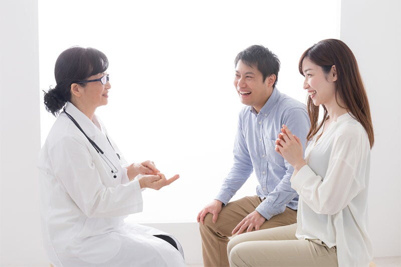 A young Asian couple talking to their ob-gyn about their birth plan