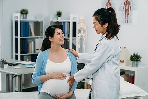 A young Asian woman talking to a female doctor at the clinic