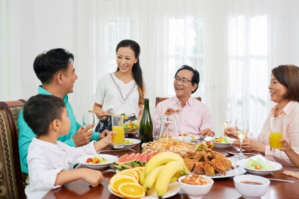 A big Asian family eating and talking happily during Easter at the dining table.