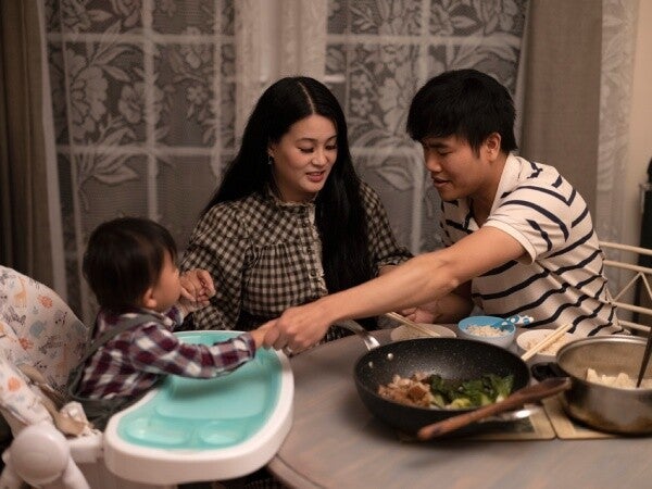Asian family saying a prayer before dinner.