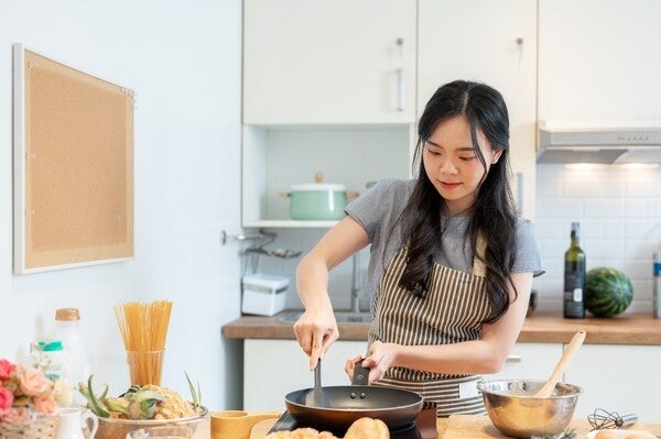 Asian woman cooking healthy meals in the kitchen.