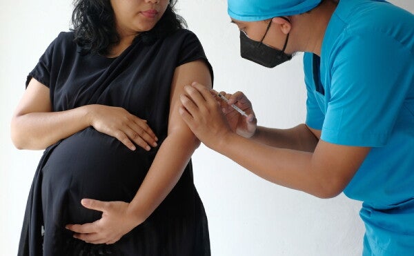 Asian doctor injects one of the vaccines for pregnant women.