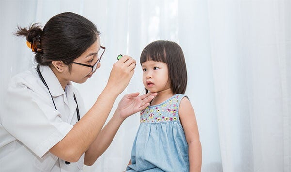 Asian doctor performs a checkup on a preschooler suspected to have diarrhea.