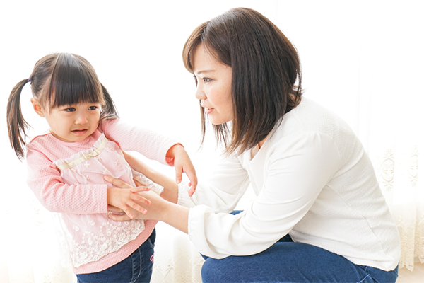 Asian female toddler refuses to listen and tries to get away from her mother
