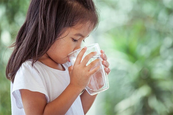 Asian girl drinking water outdoors
