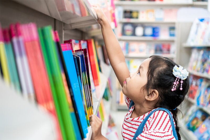 Asian girl shopping for school supplies in store
