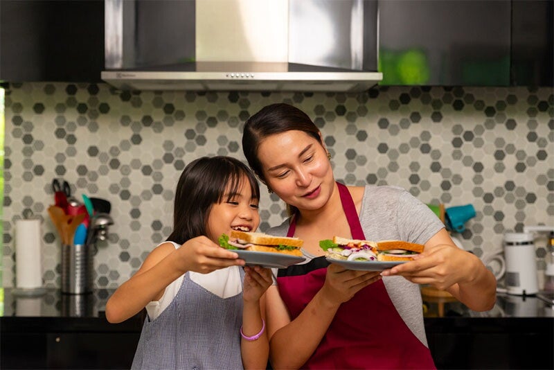 Asian mom and daughter comparing healthy sandwiches