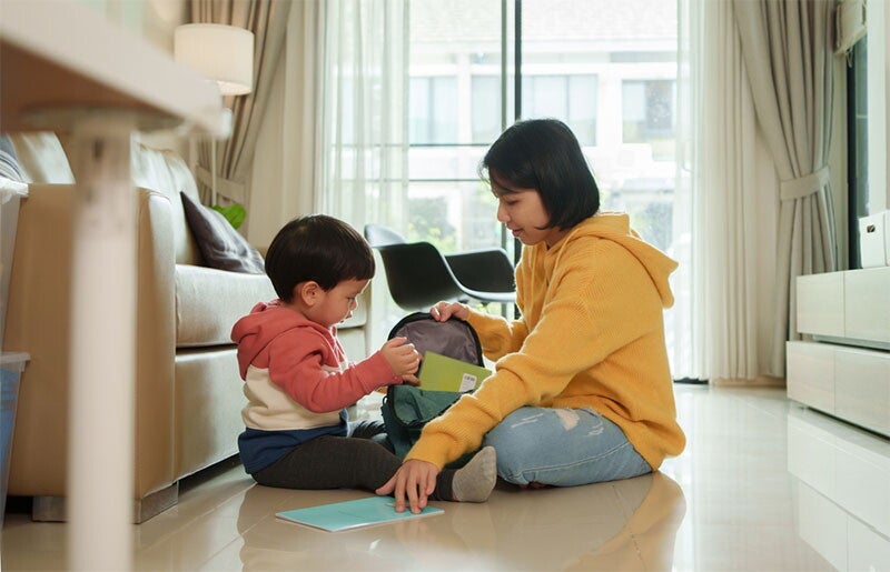 Asian mom and son going through school bag