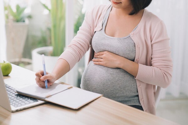 Asian self-employed pregnant woman calculates her PhilHealth premiums.