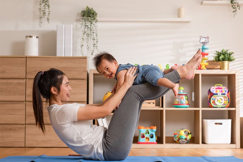 Asian woman looking at her baby trying to talk