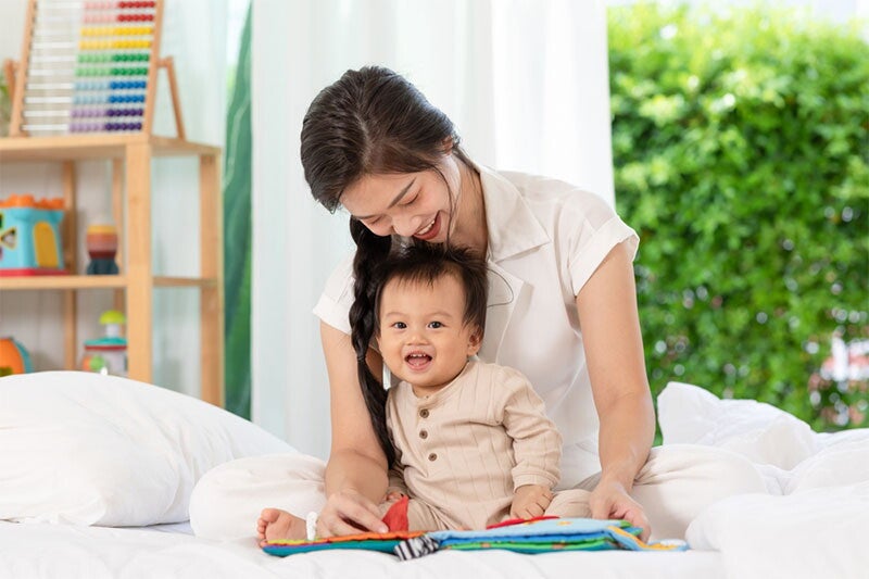 Asian woman looking at her baby trying to talk. 