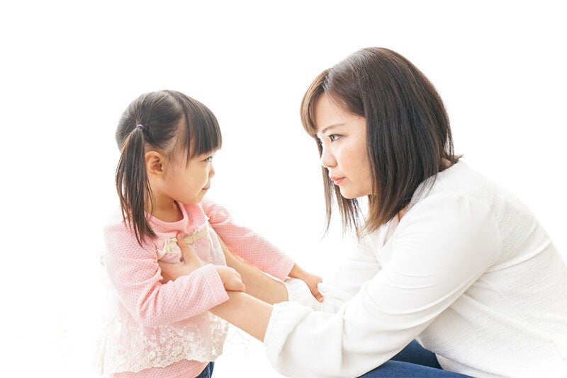 Asian woman trying to discipline her little girl