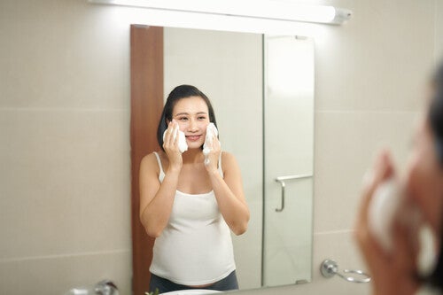 Asian woman washing her face with pregnancy-safe skin care in the bathroom