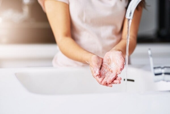 Close-up shot of an unrecognizable woman washing her hands.