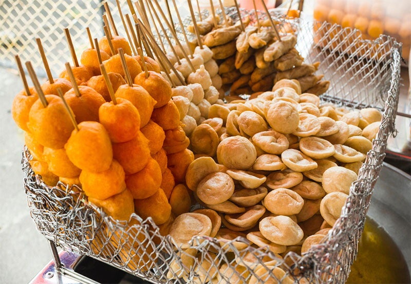 Closeup of fishballs and kwekwek in a wire basket.
