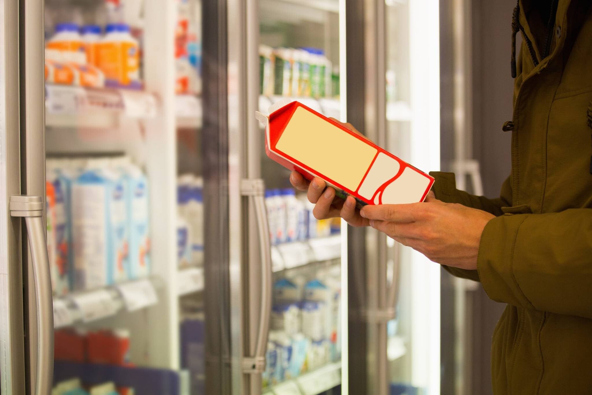 Cropped photo of a customer’s hand checking milk’s shelf-life, one of the sterilized milk benefits.