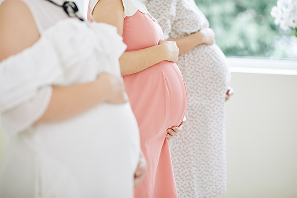 Cropped photo of the bellies of three pregnant women