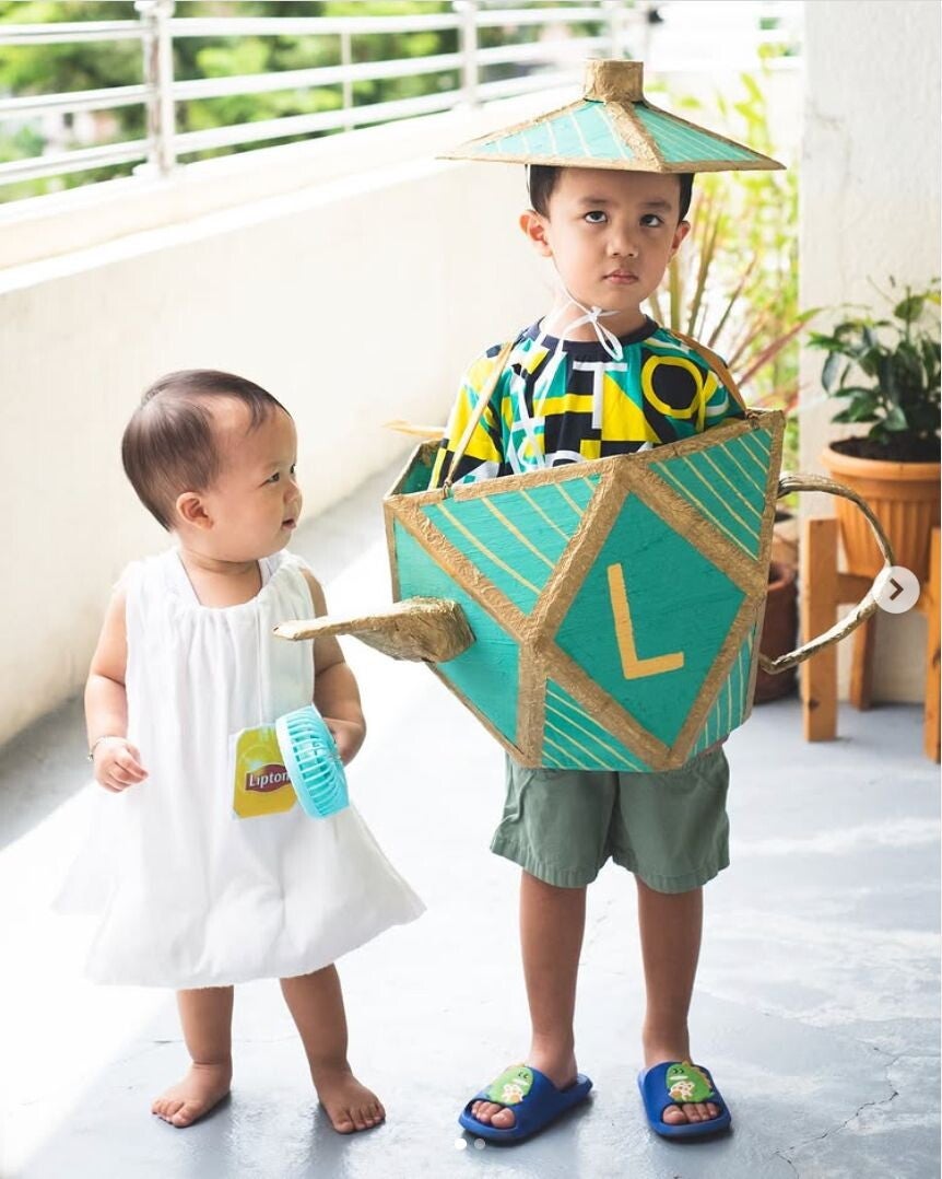 Asian children dressed up as a teapot and teabag.