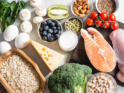 Flat lay of fruits, vegetables, dairy products, eggs, legumes, dietary meat and fish, nuts and seeds on the table.