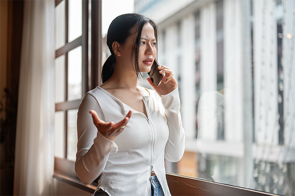 Frustrated Asian woman talking on the phone.