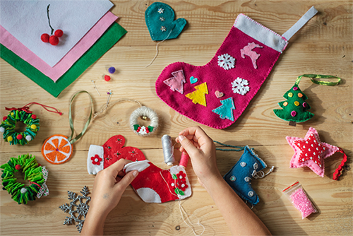 Photo of hands sewing a felt Christmas sock for the holidays.