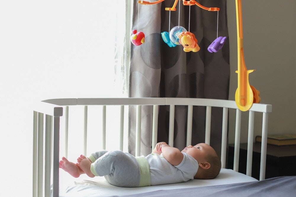 Baby co-sleeping next to grown-up bed.