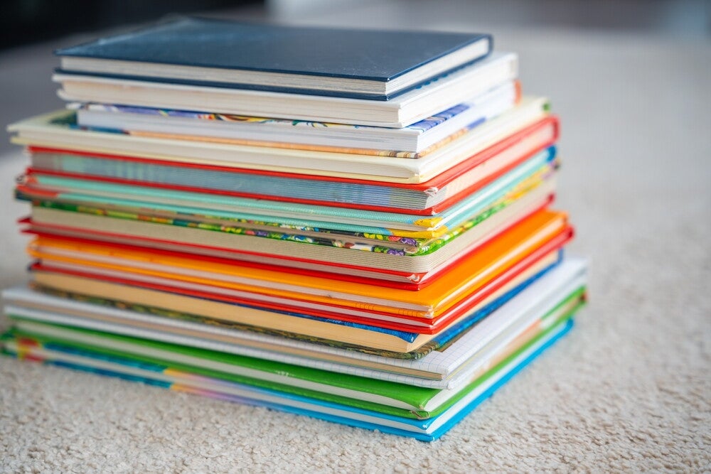 Product photo of a stack of children’s books on a carpeted floor.