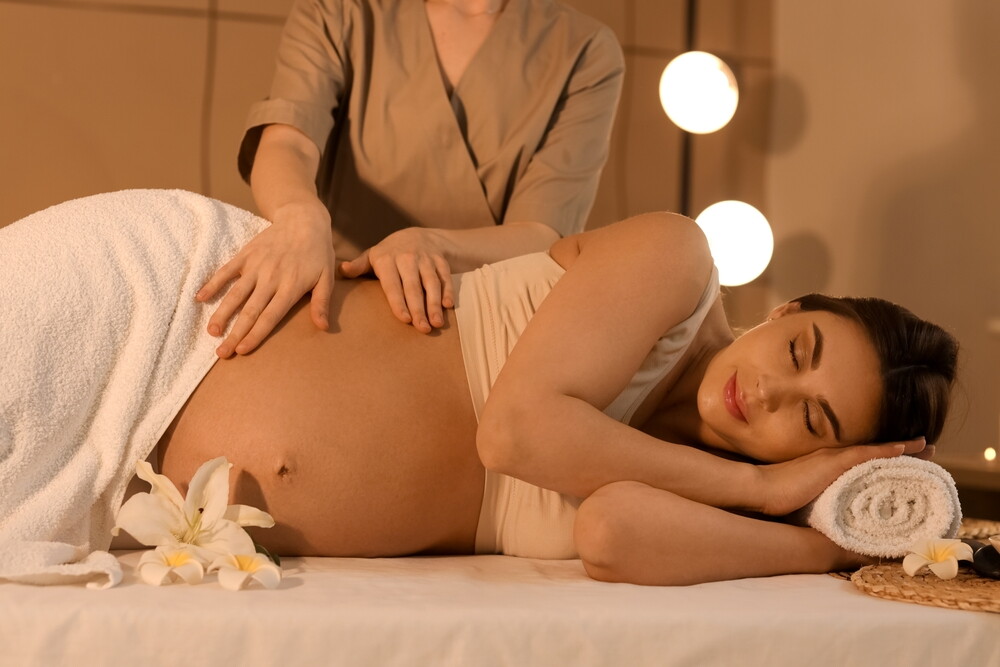 Asian pregnant woman gets a prenatal massage while on babymoon.