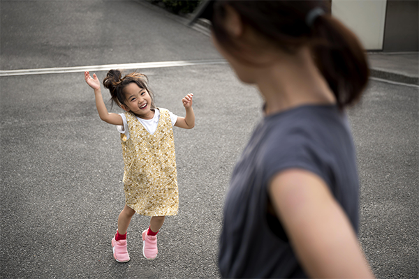 Mom is playing with her daughter outside the house