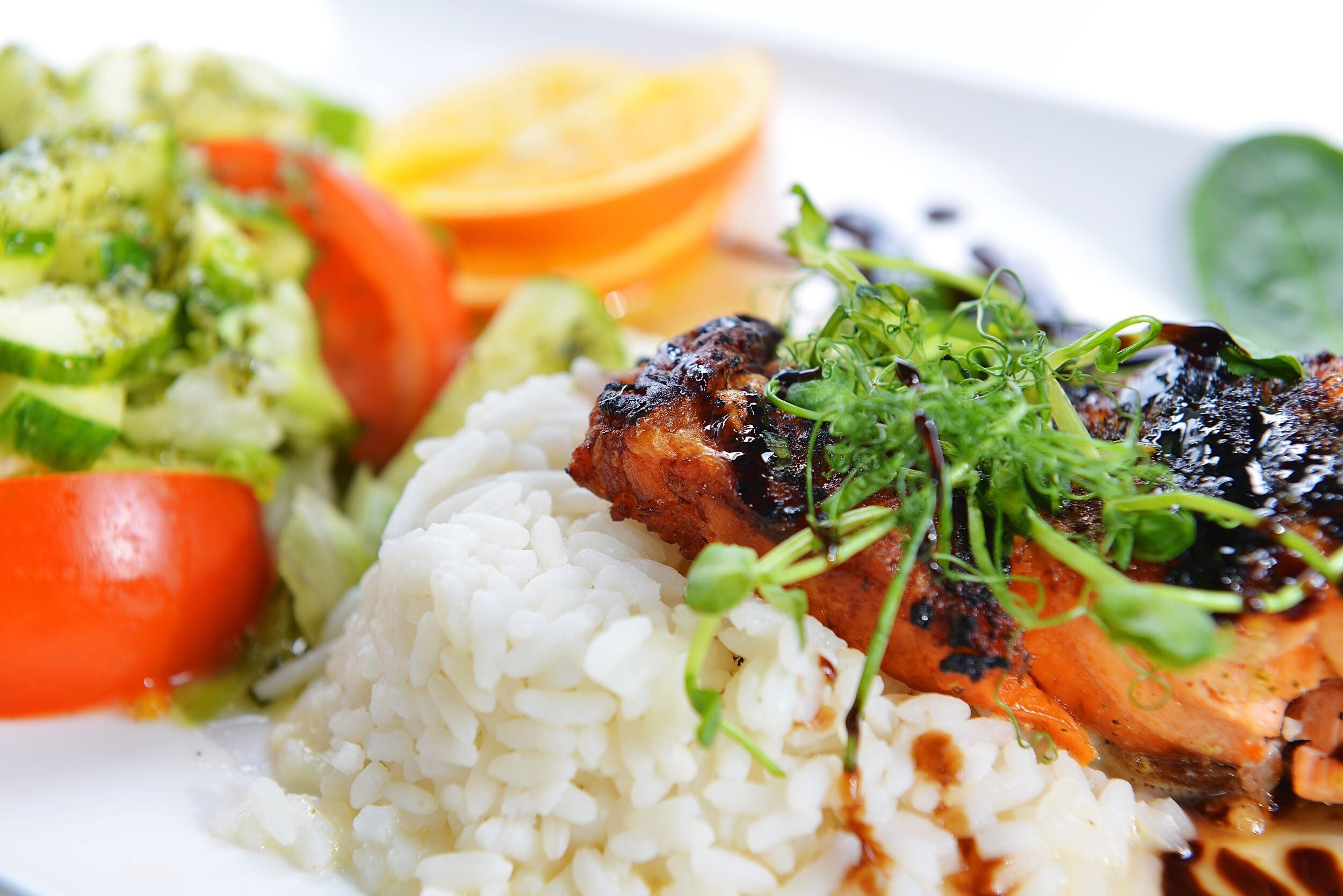 Close-up of a plate of vegetables, fish, and rice. 