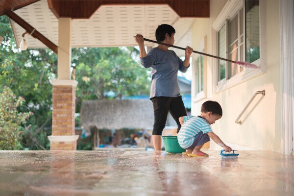 Asian mother and child clean the windows and floors respectively.