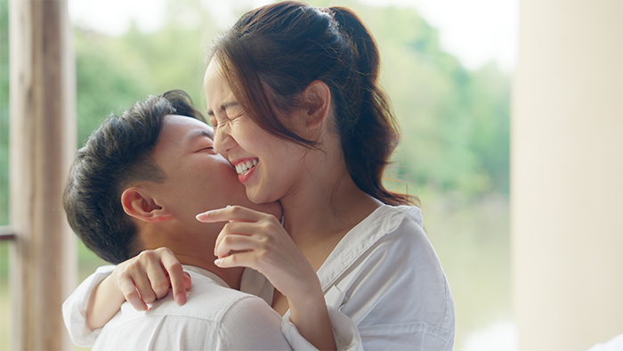 Young Asian couple kissing happily as they discuss their relationship.