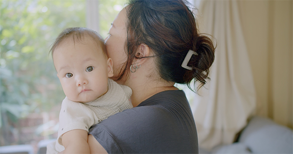 Young Asian mom hugs her baby as she worries about her breast milk production.