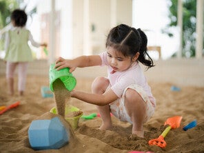 Asian girl playing with sand toys.
