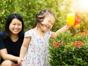 Asian mother and child water plants together happily.
