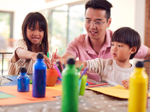 Asian dad with his kids doing arts and crafts as gift ideas for mothers