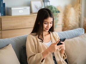 Asian woman looking at her phone's calendar to check her ovulation days Asian woman looking at her phone's calendar to check her ovulation days.
