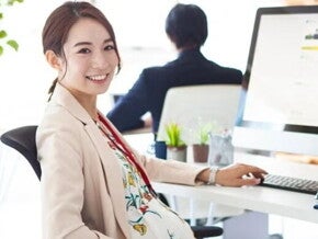 Pregnant Asian takes a break from working on her computer at an office. Pregnant Asian takes a break from working on her computer at an office.