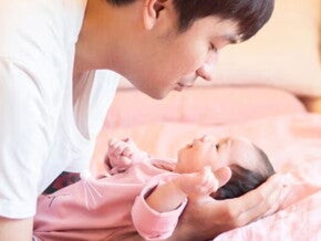 Young Filipino dad talks to his newborn while putting them down. Young Filipino dad talks to his newborn while putting them down.