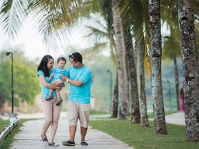 A young Asian couple with their child strolling at a park during one of the 2026 Philippine holidays.
