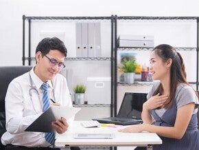 A young Asian woman talking to her doctor about her concerns regarding her high-risk pregnancy A young Asian woman talking to her doctor about her concerns regarding her high-risk pregnancy