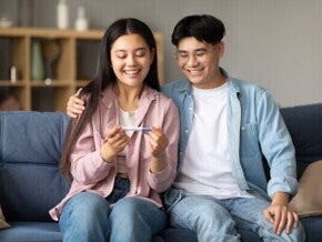 Happy Asian couple discovers they’re expecting and want to start a healthy pregnancy journey. 