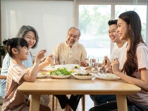 An Asian extended family eating together in the dining room.