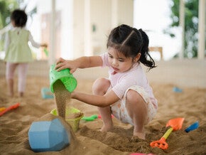 Asian girl playing with sand toys.