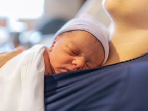 A mom holding her premature baby in the hospital, doing kangaroo mother care for skin-to-skin contact.
