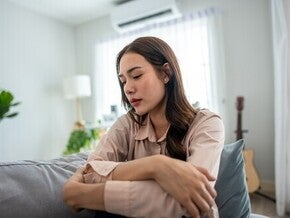 Upset Asian woman feeling emotional due to pregnancy hormones and mood swings in the first trimester
