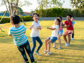 Asian children of mixed genders play tug-of-war outdoors