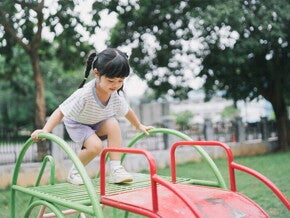 Asian girl, who doesn't show any signs of low calcium, climbs up the slide at a playground. Asian girl, who doesn't show any signs of low calcium, climbs up the slide at a playground.