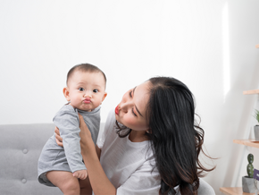 Asian mom playfully imitates her 1-year-old baby's pouting lips