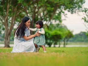 Asian mom trying to console her crying toddler